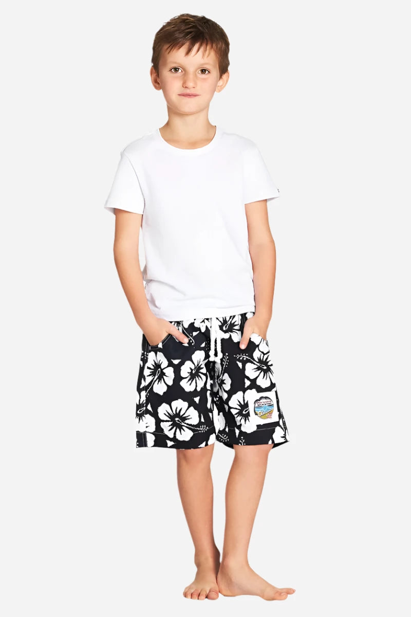 A classic white and black color hibiscus flower short worn with a simple white top shirt. 