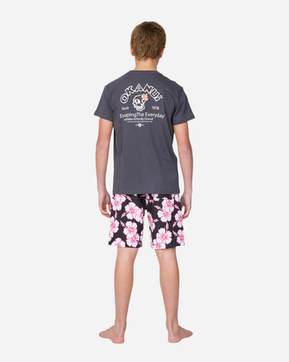 Full body back view of a boy in gray tshirt paired with Okanui kids boardrider boardshort in Black Pink