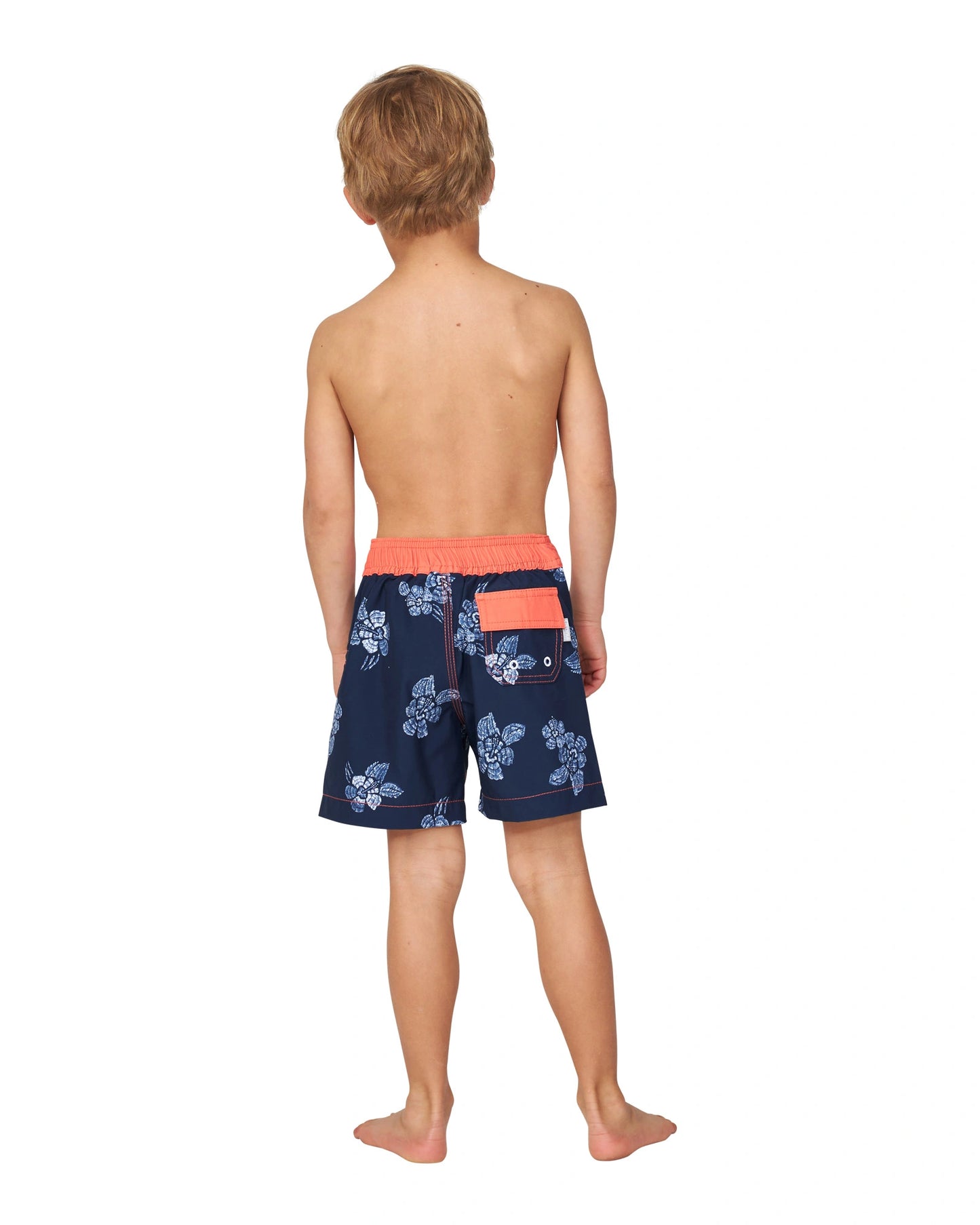 Full body back view of a topless little boy wearing the Okanui boardrider board shorts for kids in White Navy