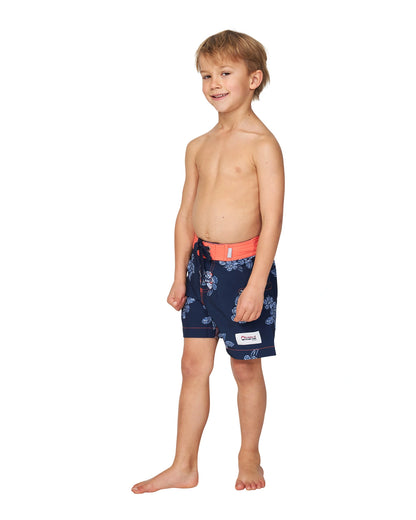 Angled front view of a topless little boy wearing the Okanui boardrider board shorts for kids in White Navy