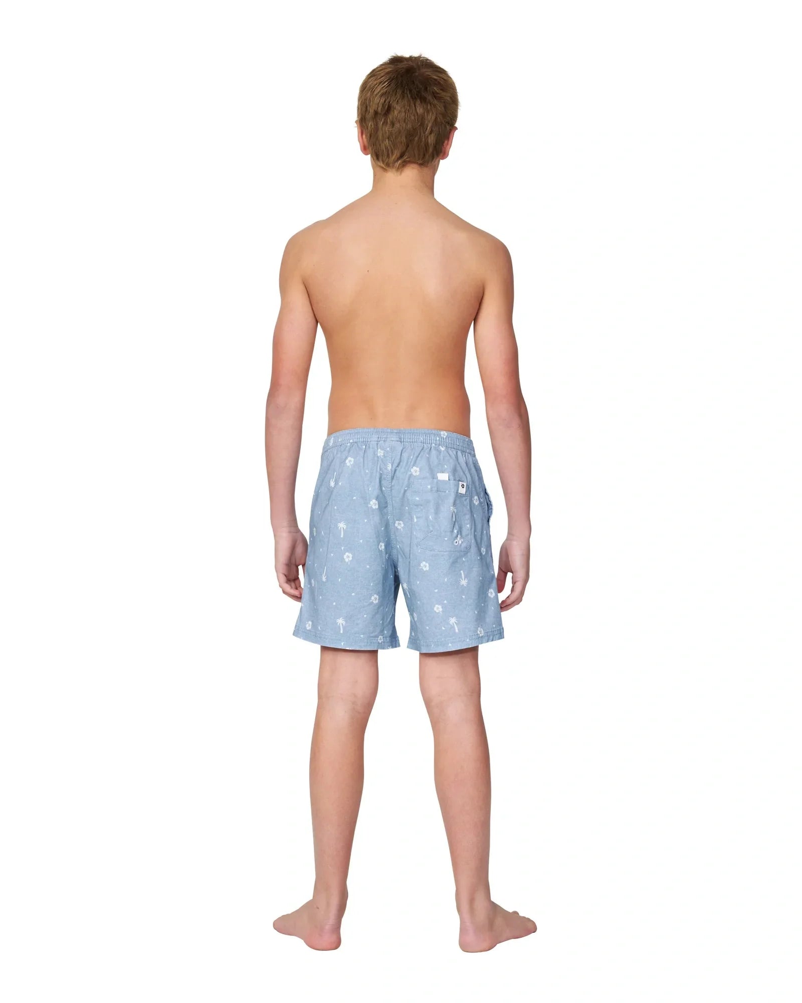 Full body back view of a boy wearing the Okanui walk shorts for boys in washed denim