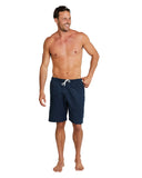 A whole body pose of a male model wearing the Okanui Linen short for men in navy color.