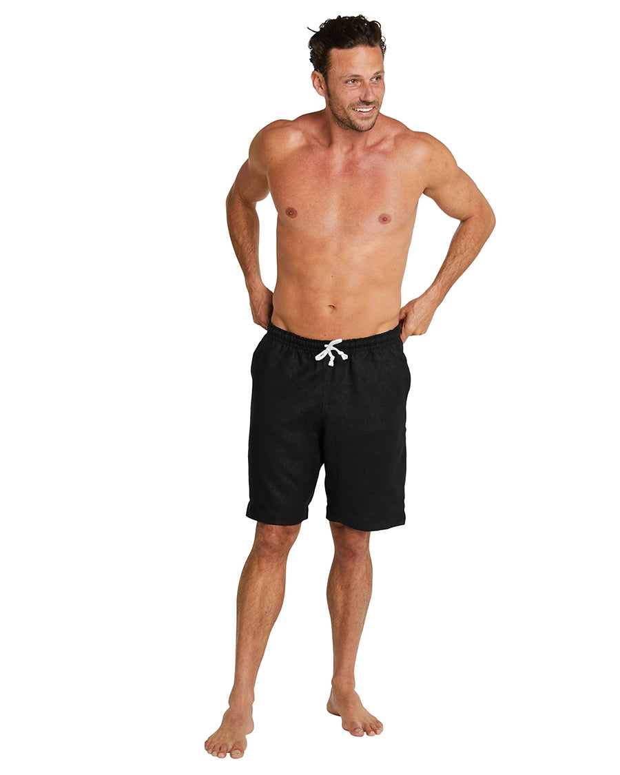 Full body front view of a male model wearing the Okanui Linen walking shorts for men