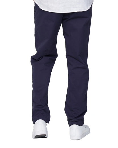 A closer view of the Okanui Wilson Chino Pants in navy color paired with white shoes and white shirt.