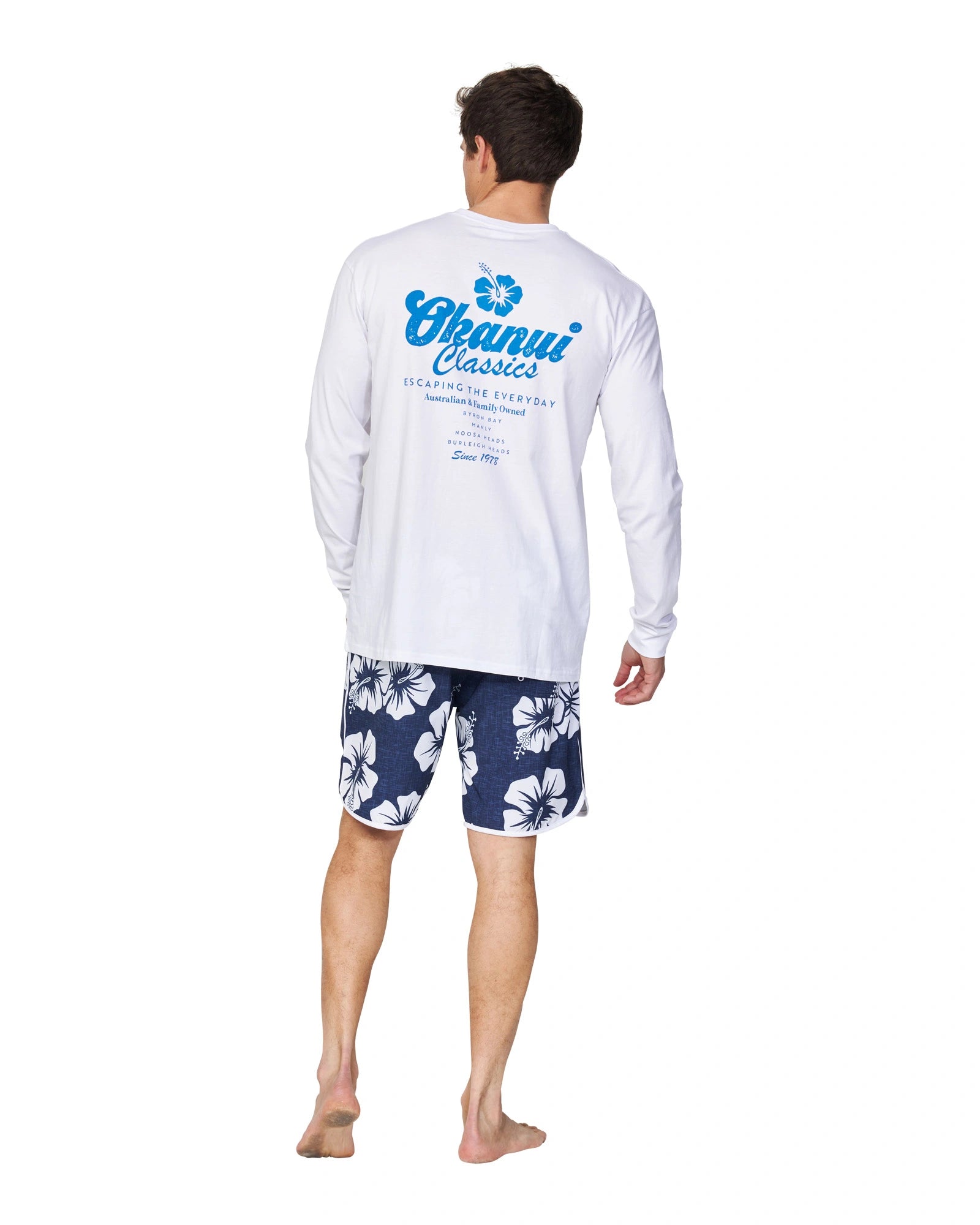 The Okanui Fast Lane Long Sleeve T-shirt in white colour worn by a model casually posing with his back on the camera.