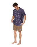 A man posing in a slightly side profile showcasing another angle of the Okanui Icons Coastal Short Sleeve Aloha Shirt in navy colour,