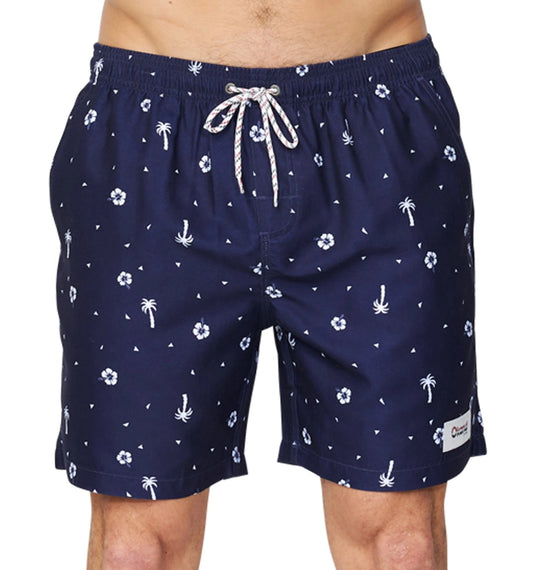 The Okanui Icons Swimshort in navy colour featuring small white prints of Hibiscus flowers and coconut trees with a logo patch on the left leg.