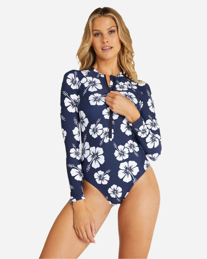 Front view of a female model wearing the Okanui womens long sleeve rash vest in Hibiscus Navy