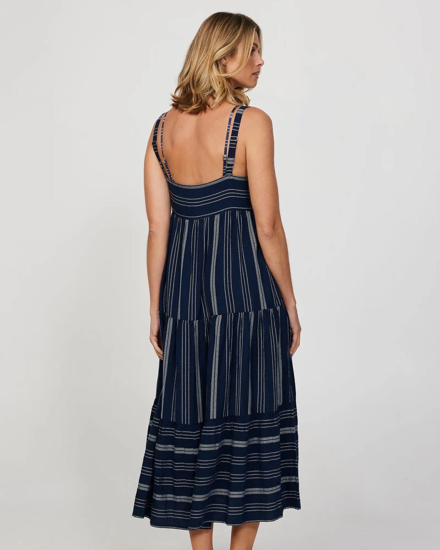 Full back view of a female model wearing a long navy Okanui Dress.