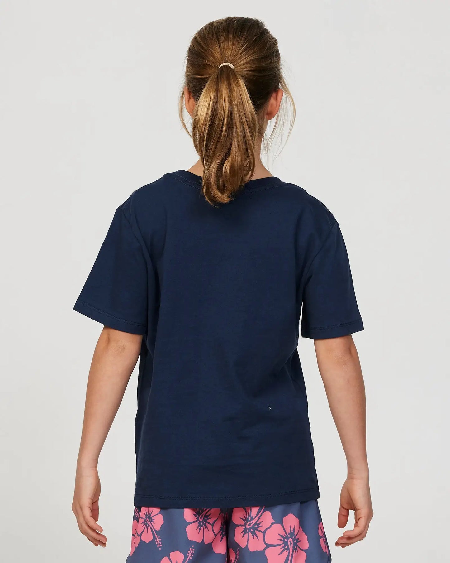 Closeup back view of a little girl model wearing the Okanui Signature Tee T-shirt in Steel