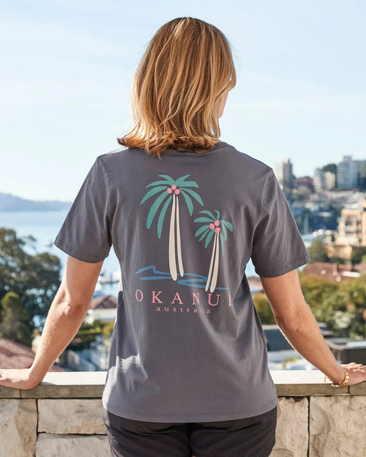 Female model showcasing the back print of Okanui Resort Tee.