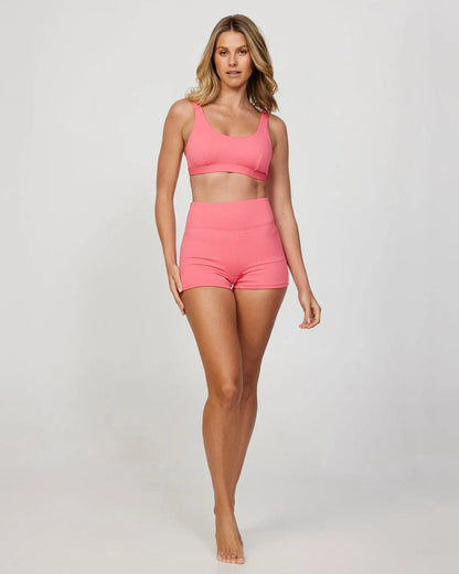 Full body front view of a female model wearing the Okanui Ribbed Bikini Crop top in Pink Rib