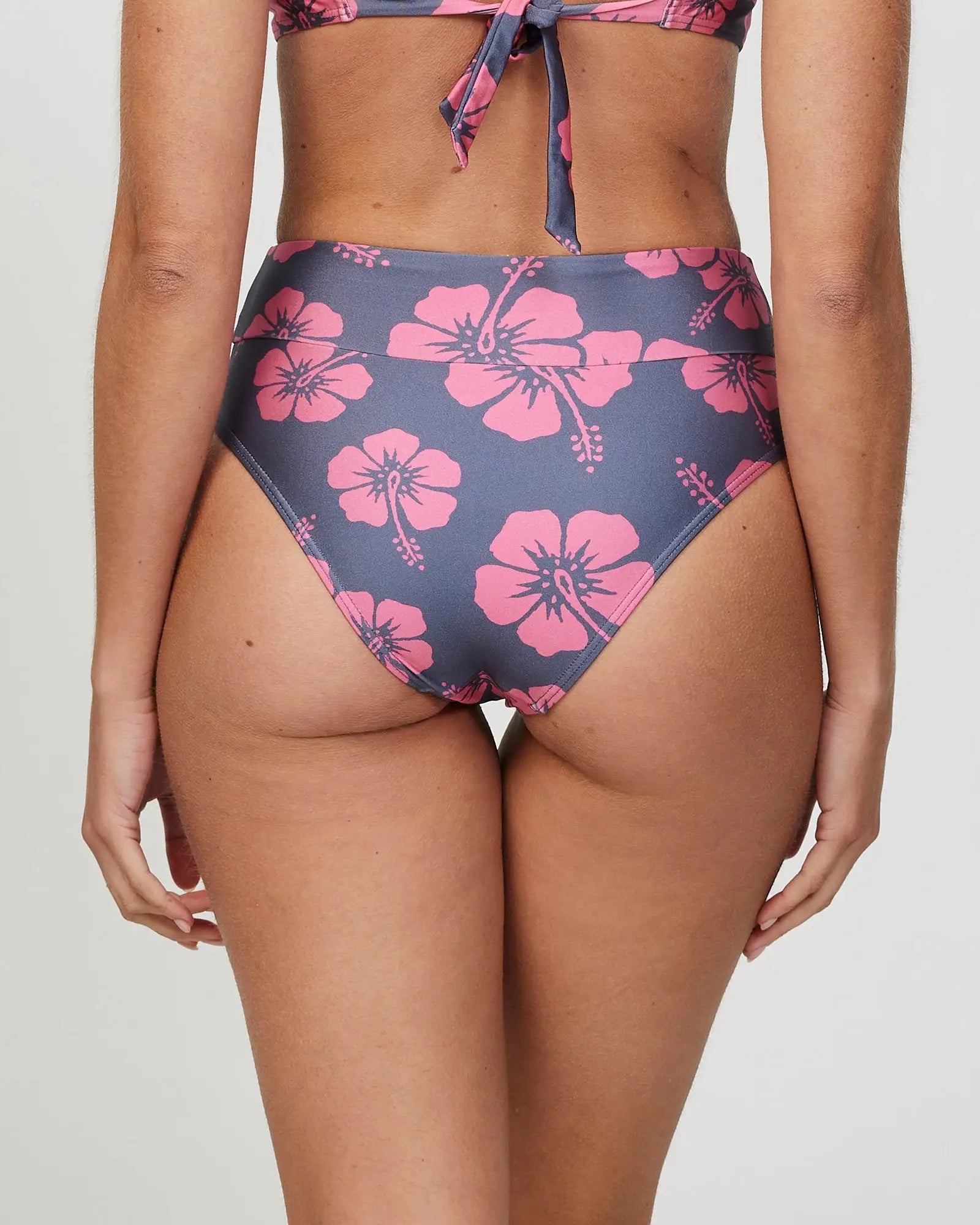 Closeup back view of a female model wearing the Okanui Sundance High Waist Pant Bikini Bottom n Hibiscus Iron Pink