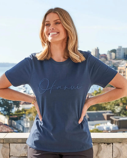 Female model wearing a navy Okanui Signature Tee