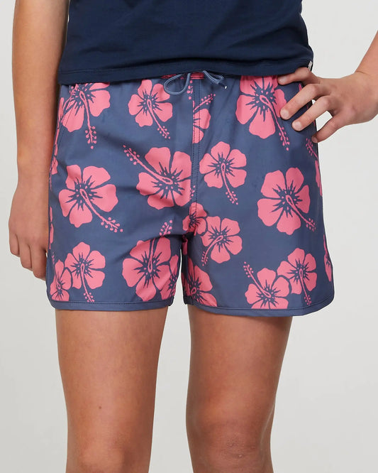 Closeup front view of a girl model wearing the Okanui swim short for girls in Hibiscus Iron Pink