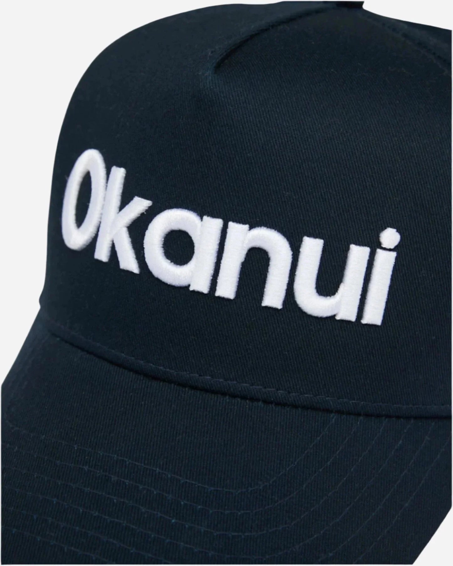 Closeup view of the Okanui Snapback Trucker Cap Logo in Navy Color