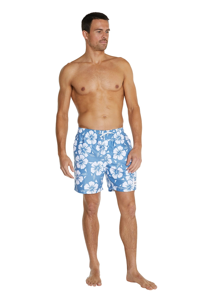 A male model wearing the Okanui Mens Swim Shorts featuring a Hibiscus flower print pattern in Steel color.