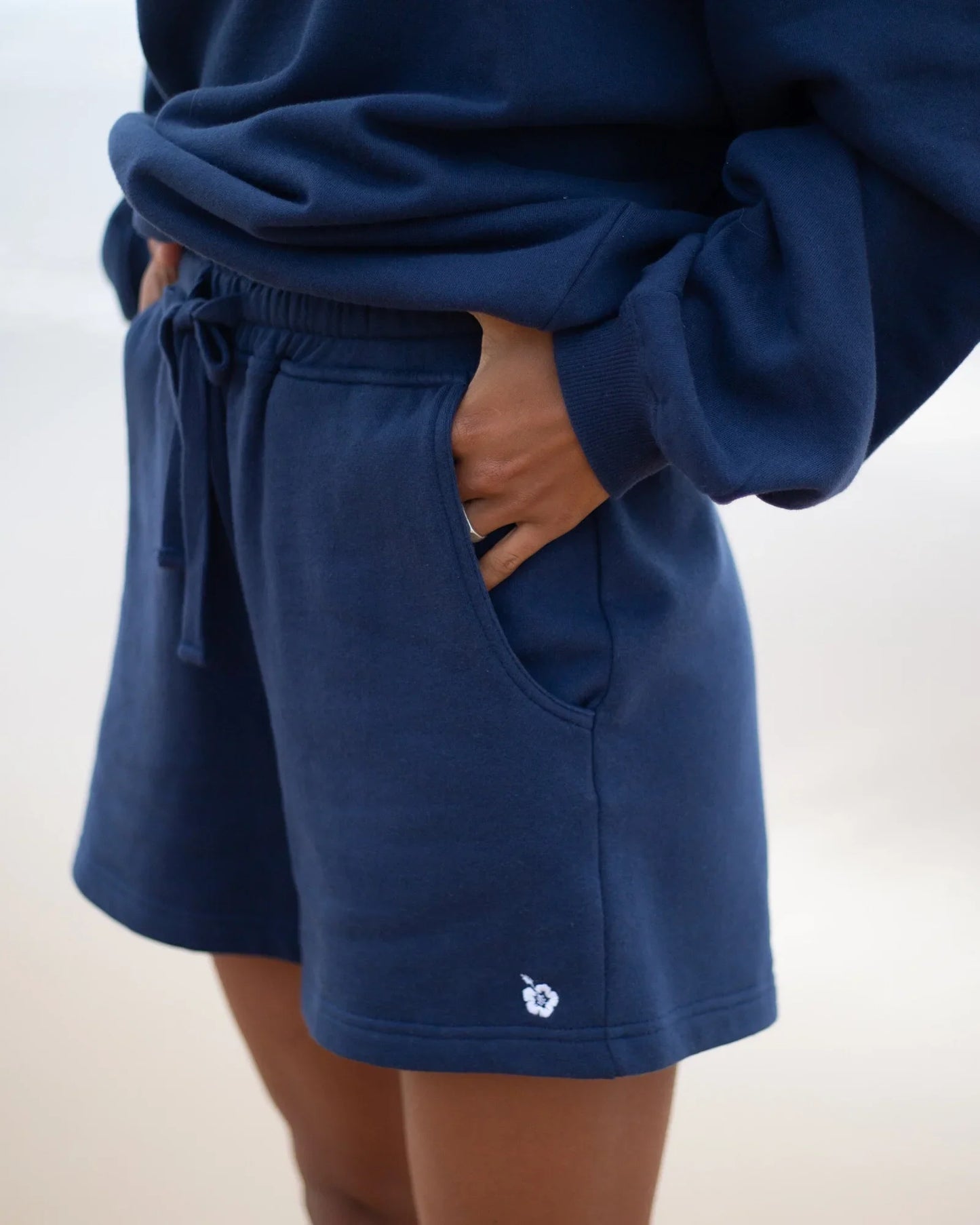 Womens fleece short in navy blue color showing the side pocket.