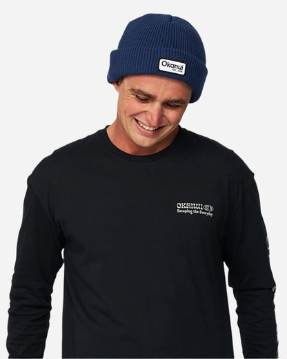 Close up view of a male model in black long sleeves wearing the Okanui Fisherman's Rib Knit Beanie Hat for Men in Navy Color