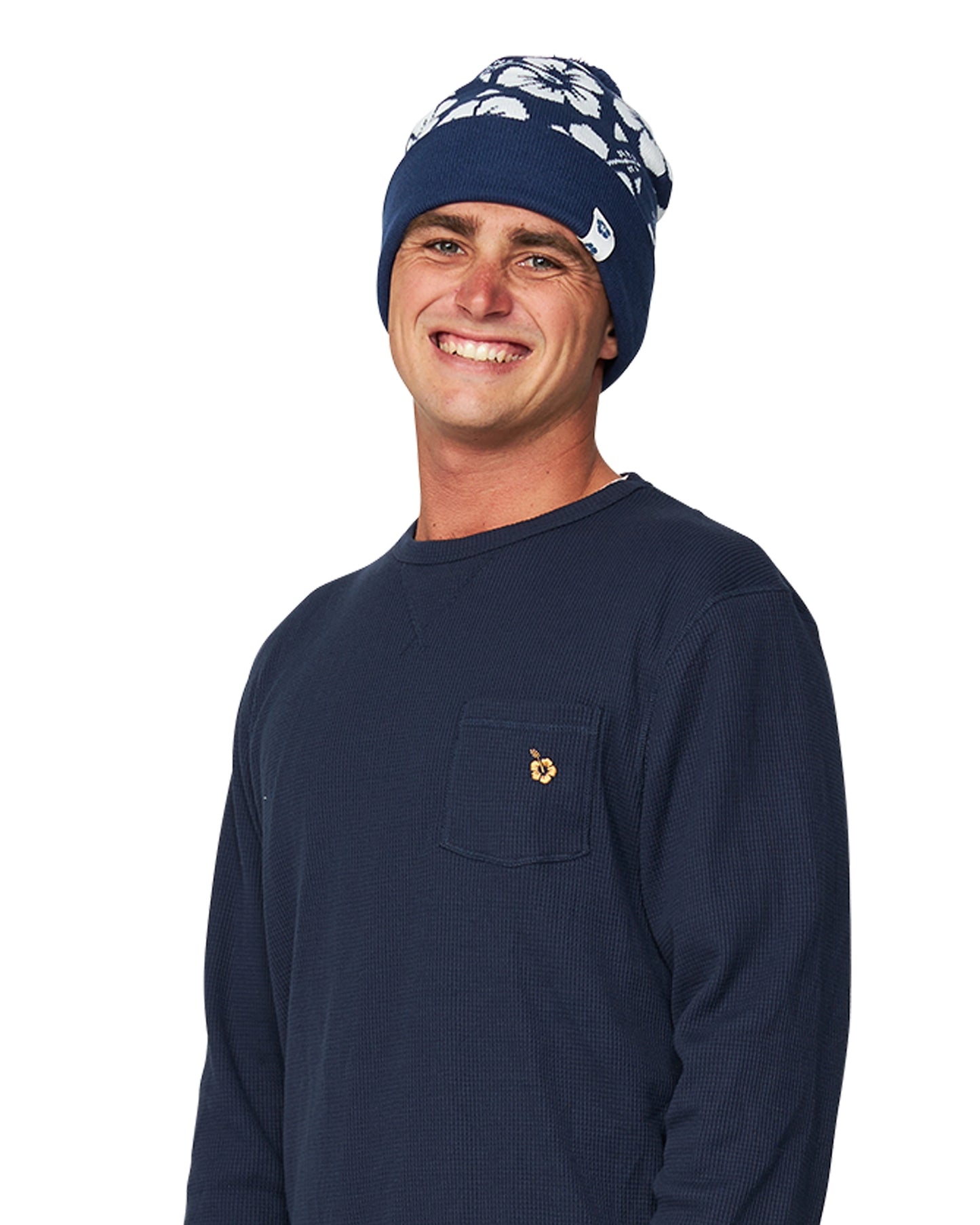 Close up view of a male model wearing the Okanui Hibiscus Rib knit Pom Pom beanie hat in Navy color