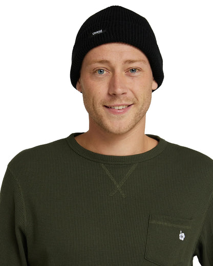 Front view of a male model wearing the Okanui Fisherman's Rib knit beanie hat anti anti black variant