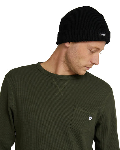 Male model looking at the left wearing the Front view of a male model wearing the Okanui Fisherman's Rib knit beanie hat anti anti black variant