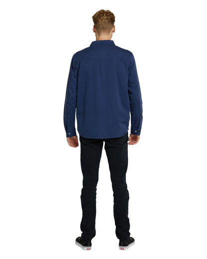 Okanui mens jacket in navy blue color with white top and black pants showing the back view. 