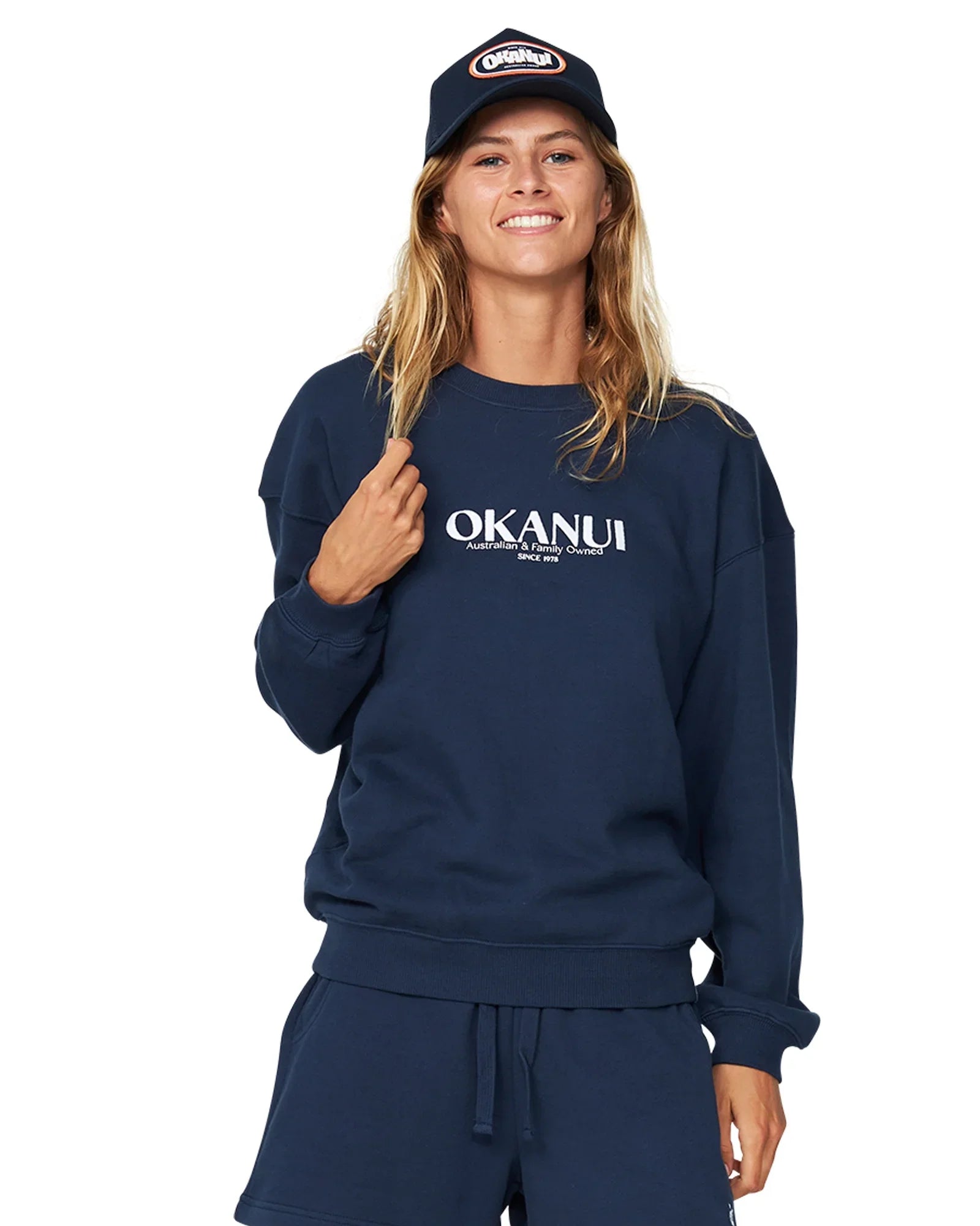 Okanui fleece in a navy blue hue, paired with a navy blue short and a cap. 