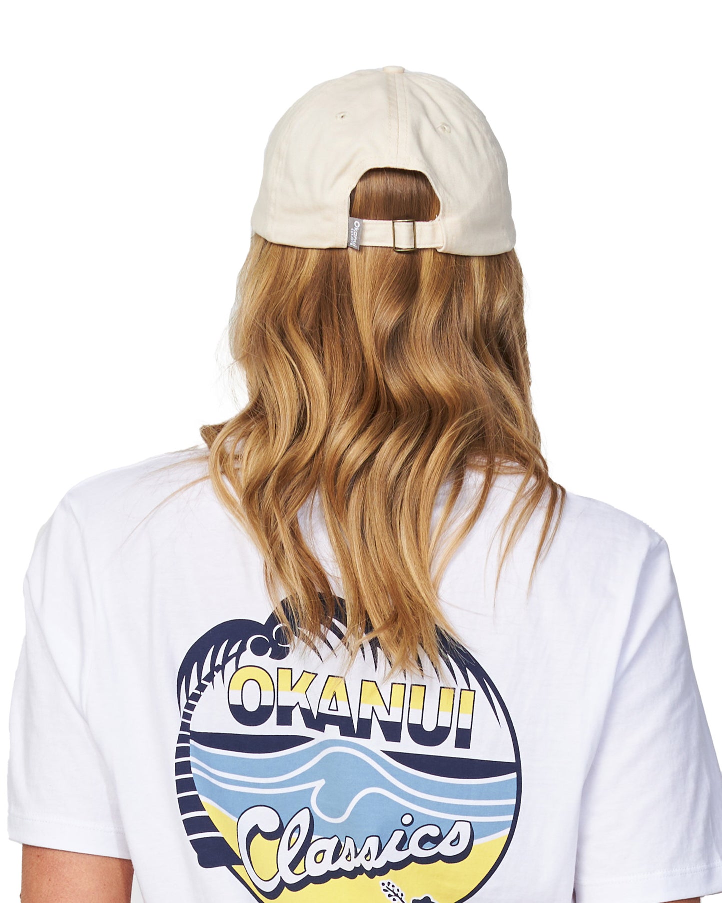 Back view of a female model wearing the Okanui Womens Snapback Trucker Cap in Natural