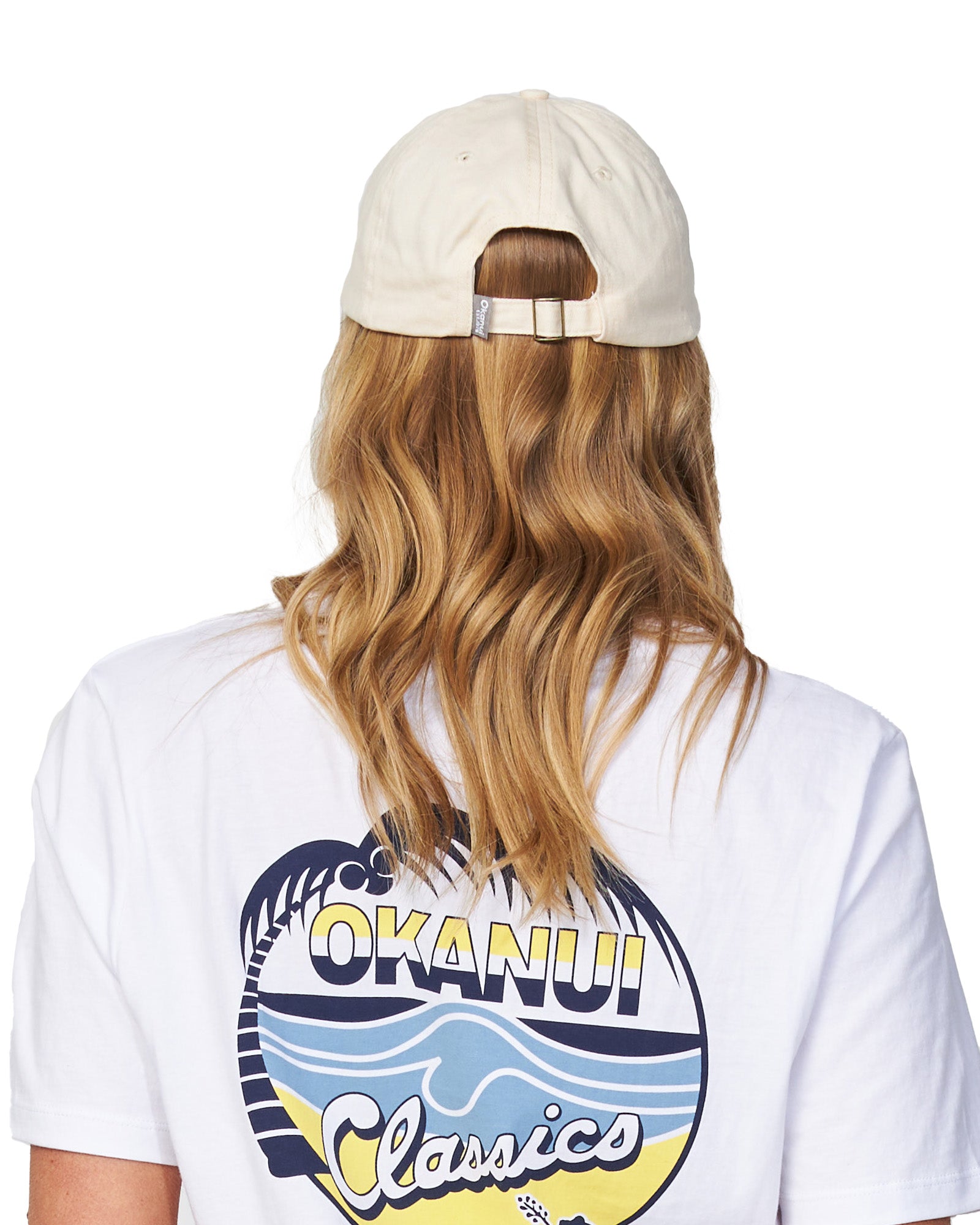 Back view of a female model wearing the Okanui Womens Snapback Trucker Cap in Natural