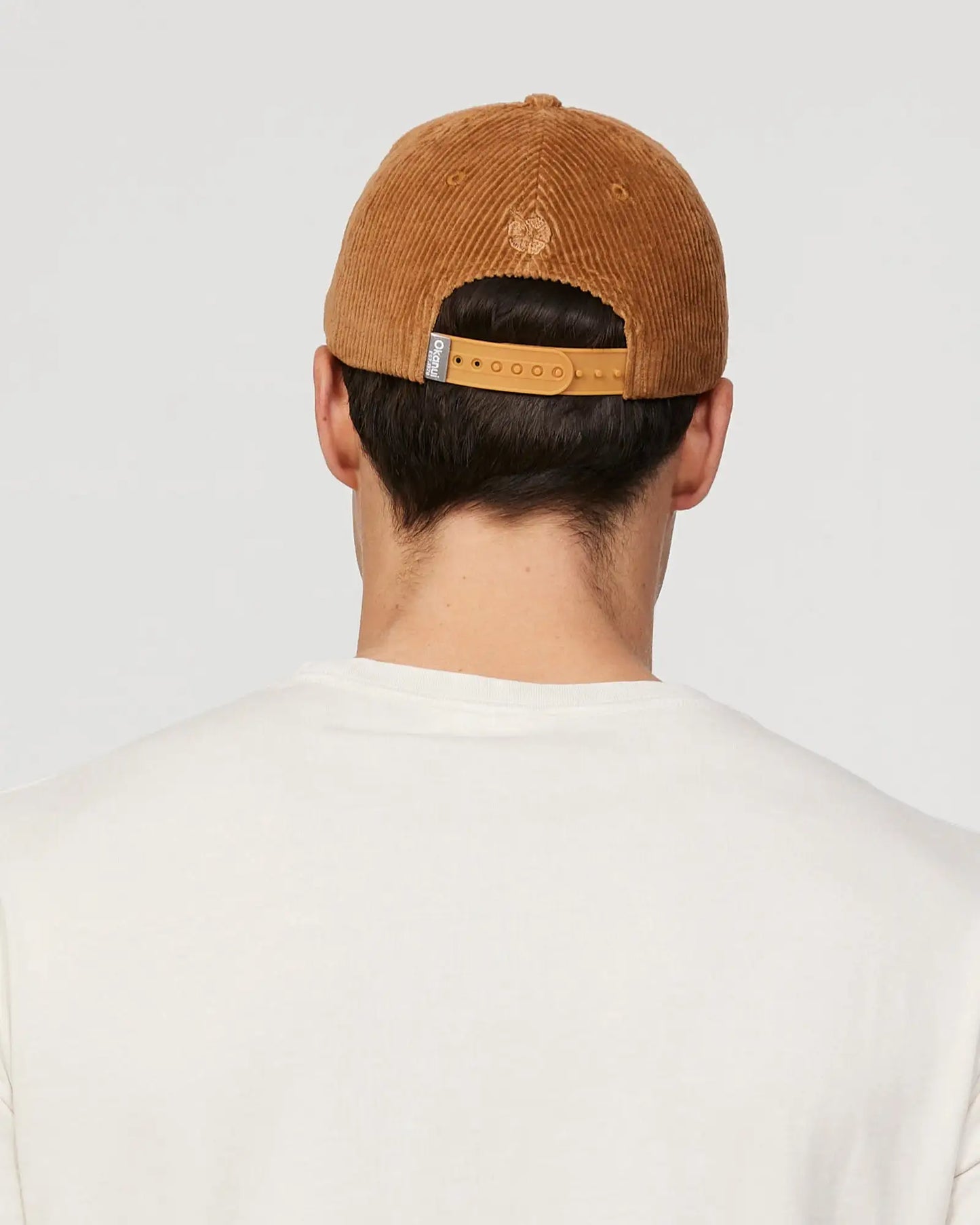 Back view of a male model wearing the Okanui sunburst corduroy trucker cap in San