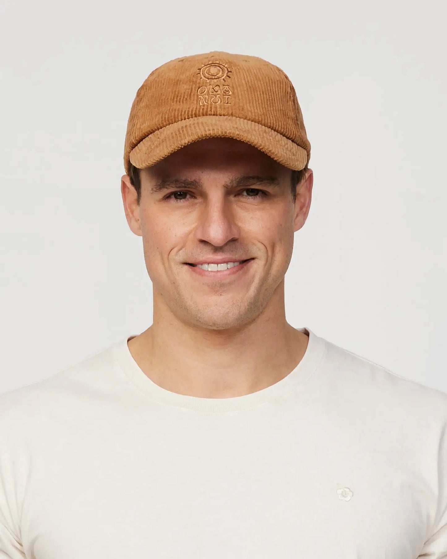 Front view of a male model wearing the Okanui sunburst corduroy trucker cap in San