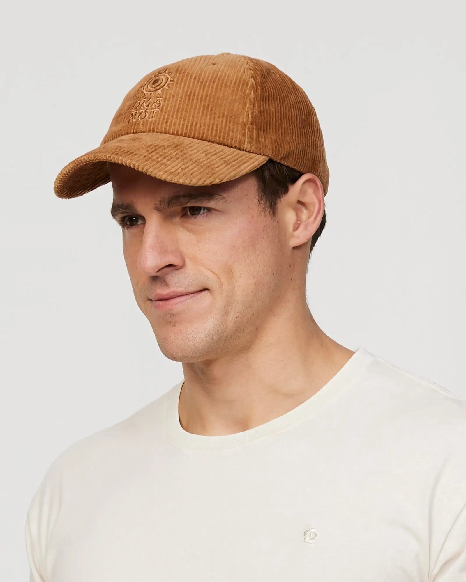 Front view of a male model wearing the Okanui sunburst corduroy trucker cap in San