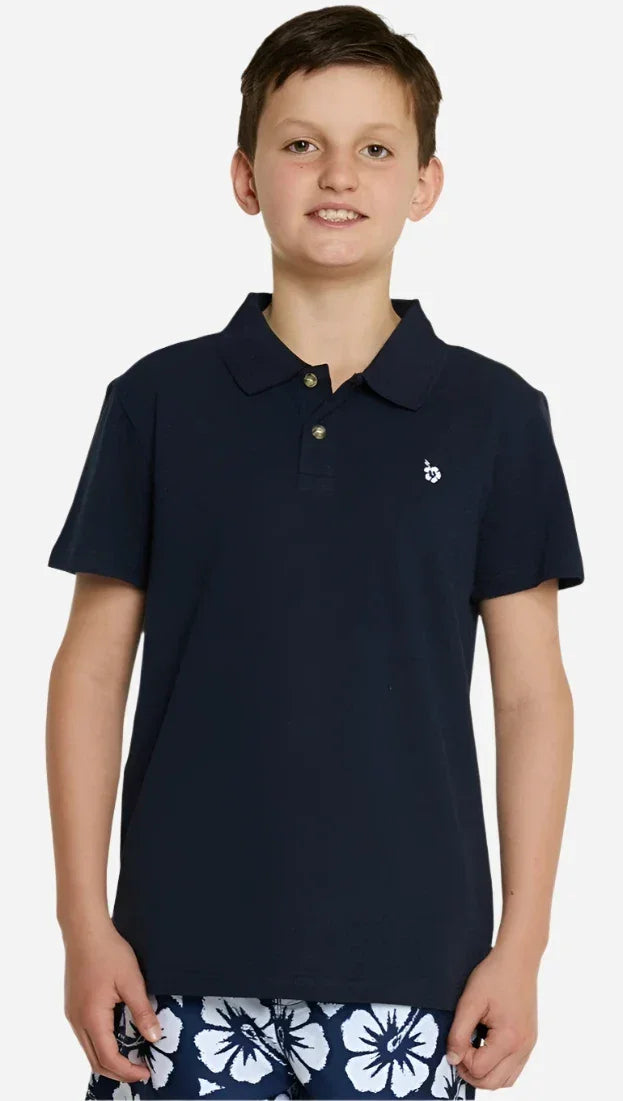 A boy wearing the Okanui classic polo shirt in Navy color, crafted from 100% cotton with a stepped hemline cut for style