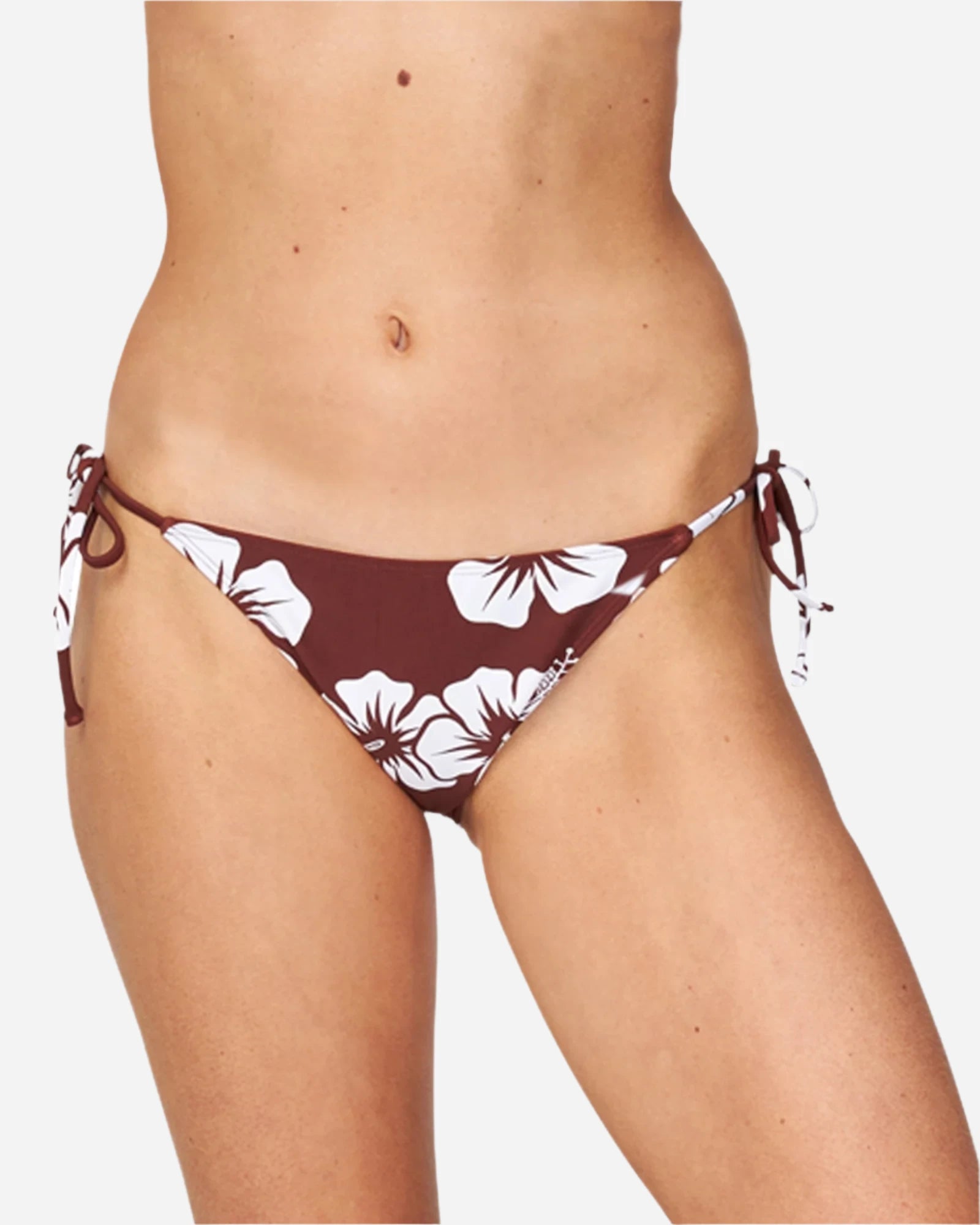 A woman wearing a hibiscus sienna swim pant with a tie-side design showing the front details. 