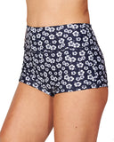 A woman wearing a surf short in hibiscus navy blue showing the side details. 