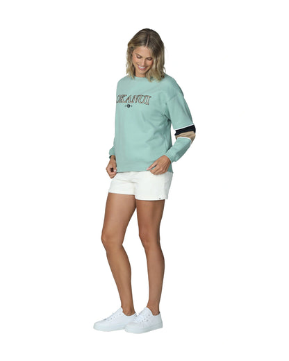  Women's sage colored winter sweater with white shorts and sneakers.