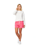 A white sweater top and hot pink fleece shorts. 