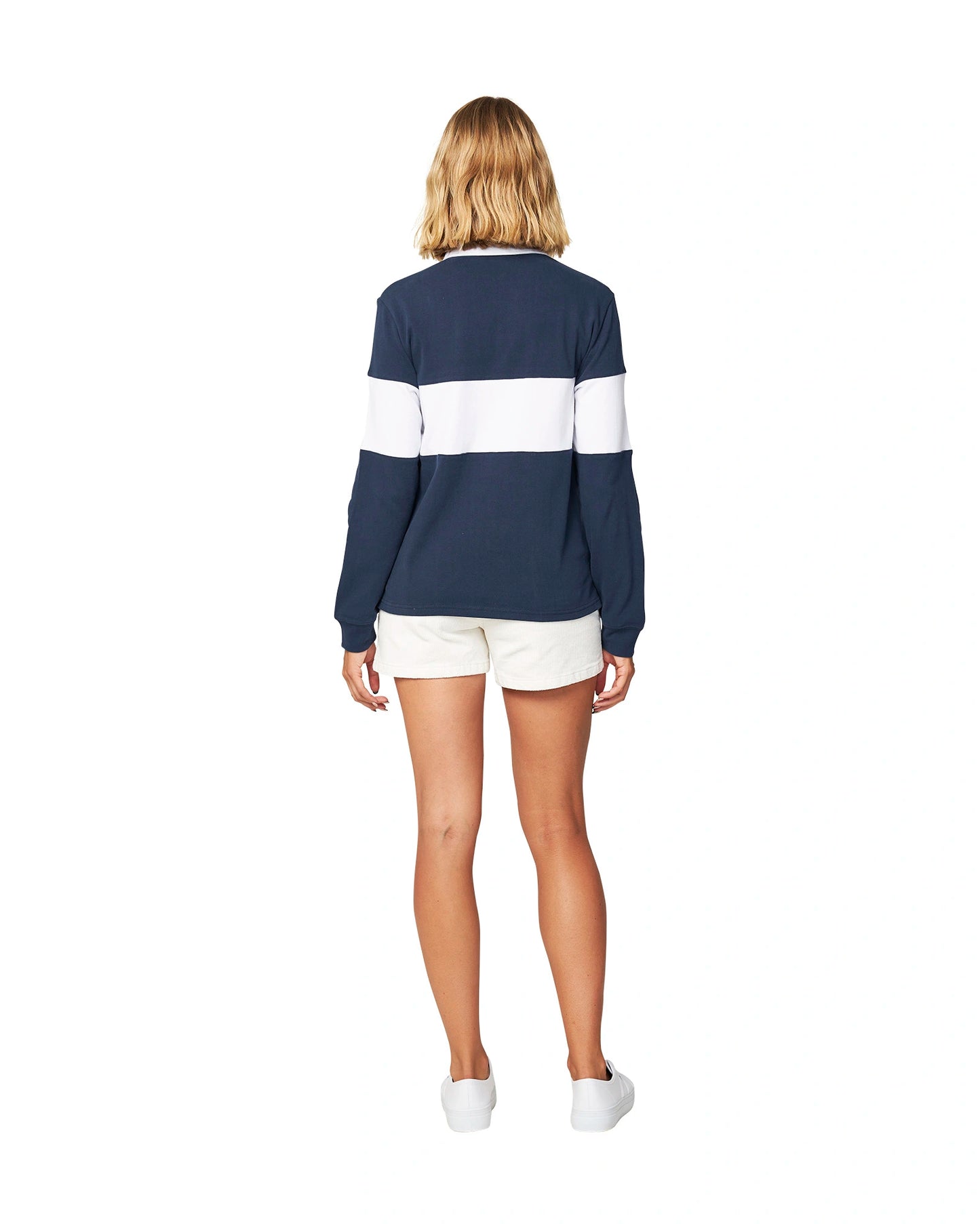 Back view of a female model wearing the Okanui Heritage rugby top jumpers paired with a white short