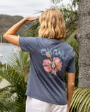 Back view of a female model wearing the Okanui Ikon cotton T-shirt in Washed Navy color