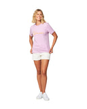 A female model with her hands in her hip wearing the Okanui Signature cotton T-shirt in Washed Lilac paired with white shorts