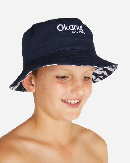 A boy wearing the Okanui reversible bucket hat, crafted from 100% premium cotton in Navy variant