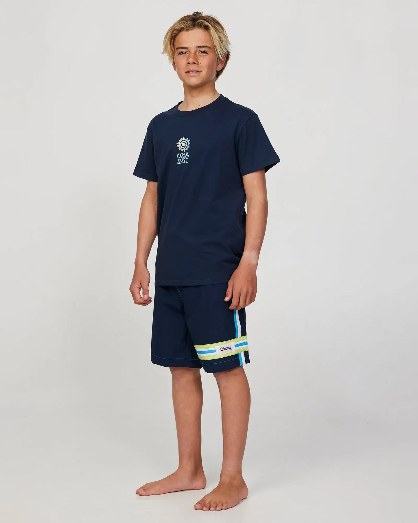 Full body front view of a boy model wearing the Okanui Twin Flame T-shirt for boys in Navy