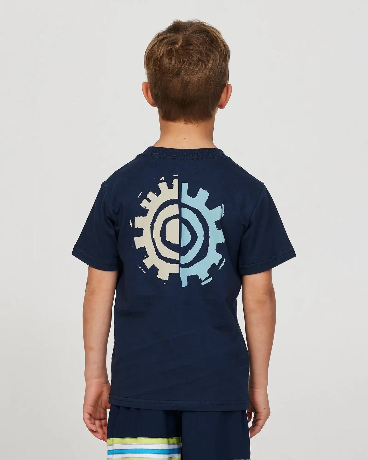 Closeup back view of a little boy model wearing the Okanui Twin Flame T-shirt for boys in Navy