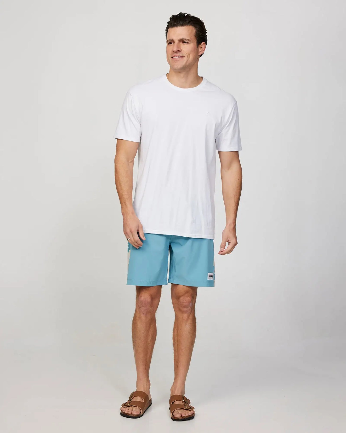 Full body front view of a male model wearing the Okanui Mens Waterworld boardrider board short in Aqua