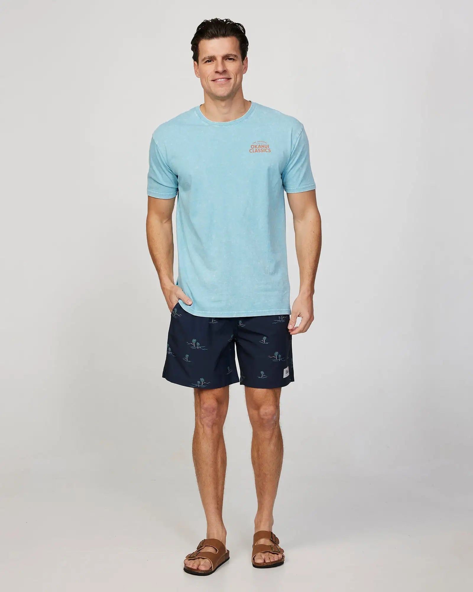 Full body front view of a male model wearing the Okanui Isle Stretch Swim Short in Black