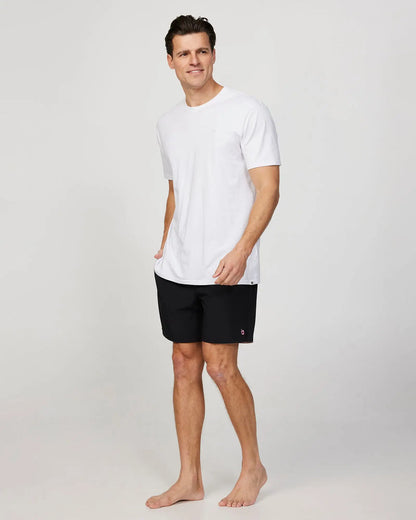 Full body left side view of a male model wearing the Okanui Mens Onboard stretch swim short in Black