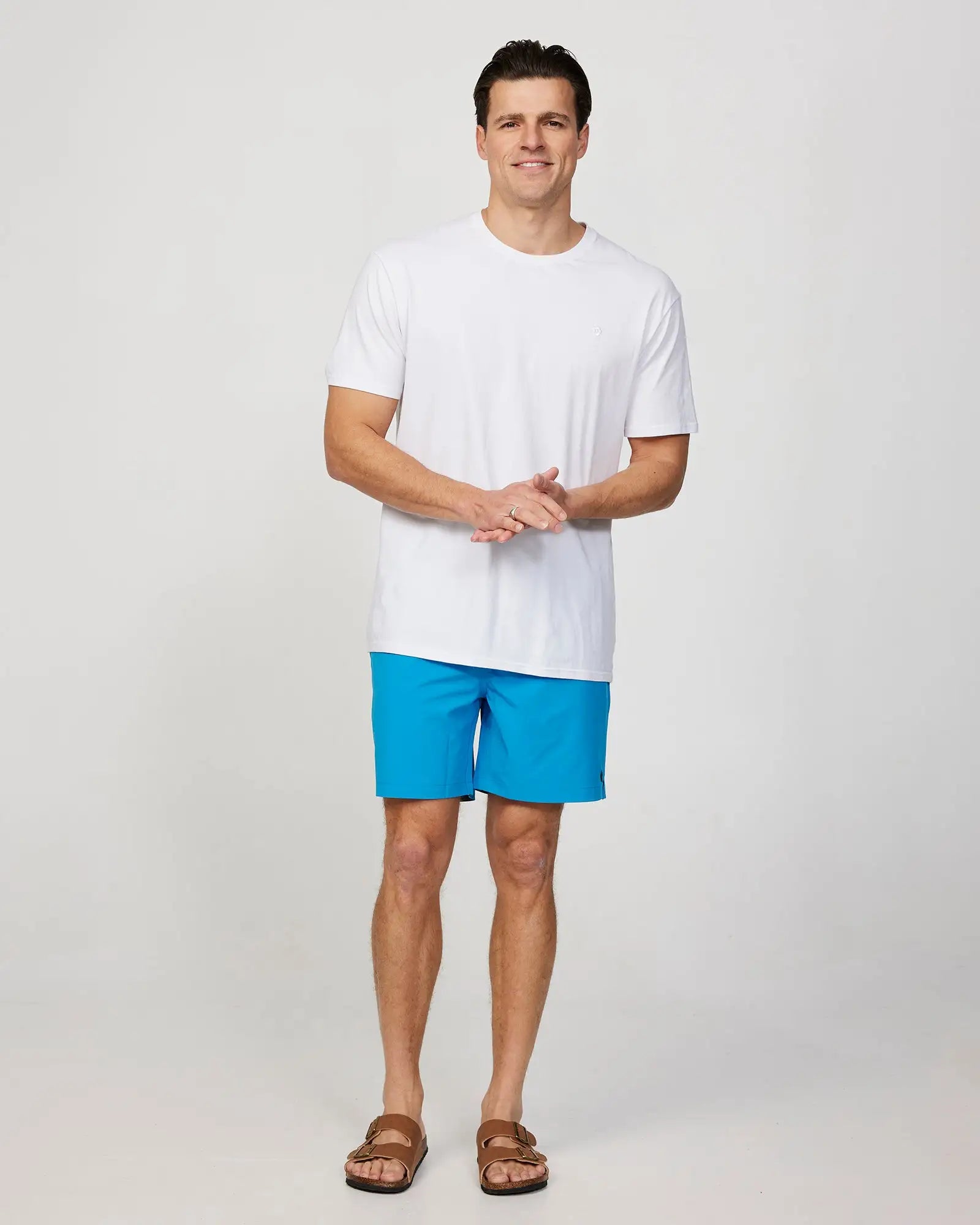 Full body front view of a male model wearing the Okanui Mens Onboard stretch swim short in Blue