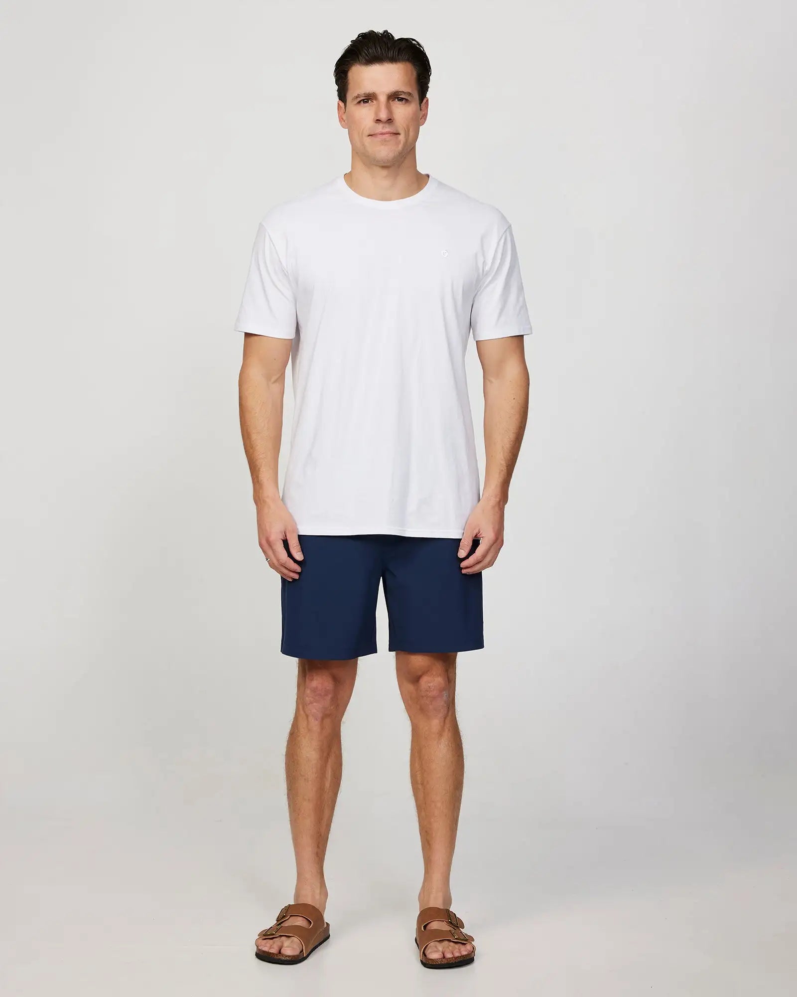 Full body front view of a male model wearing the Okanui Mens Onboard stretch swim short in Navy