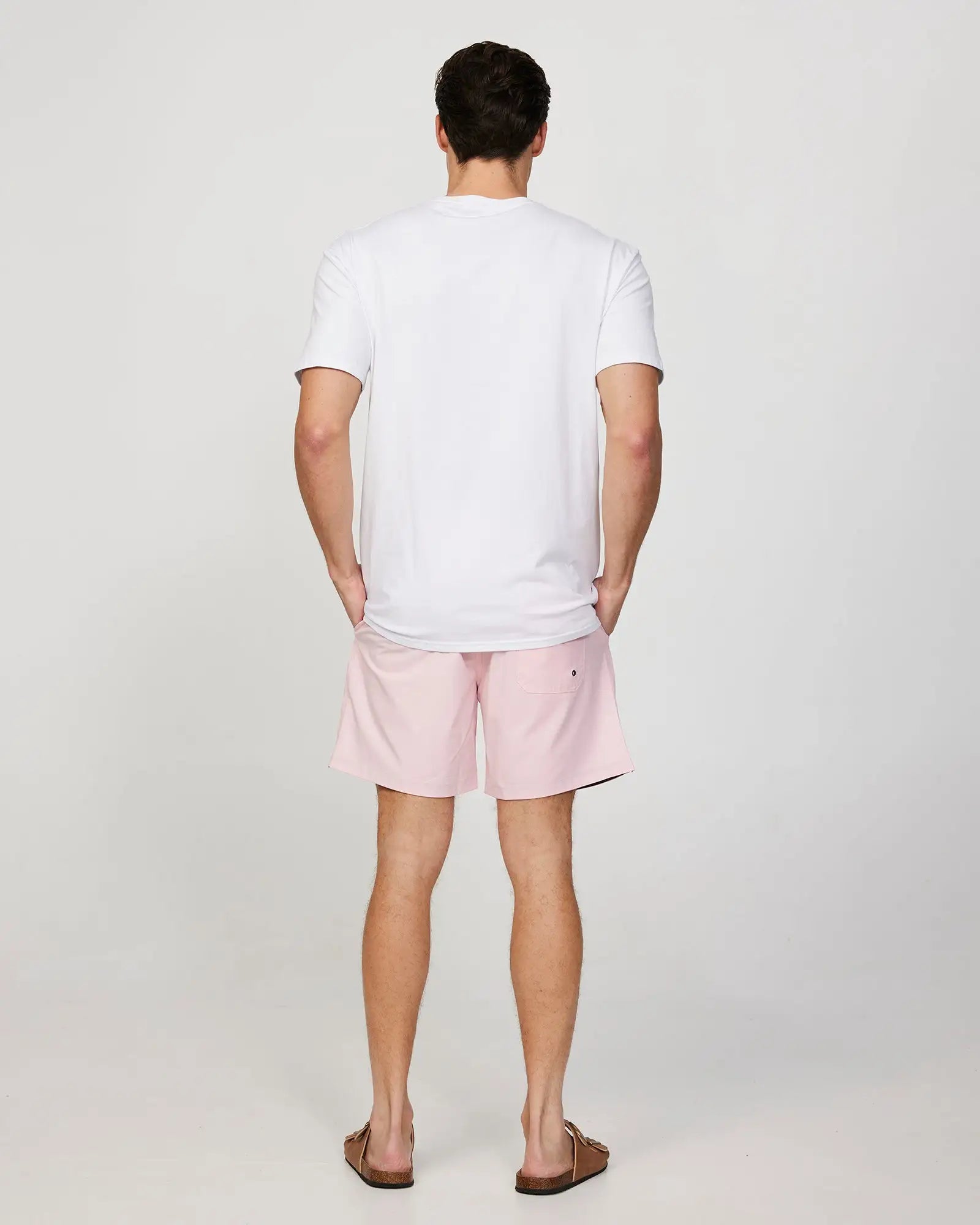 Full body back view of a male model wearing the Okanui Mens Onboard stretch swim short in Pink